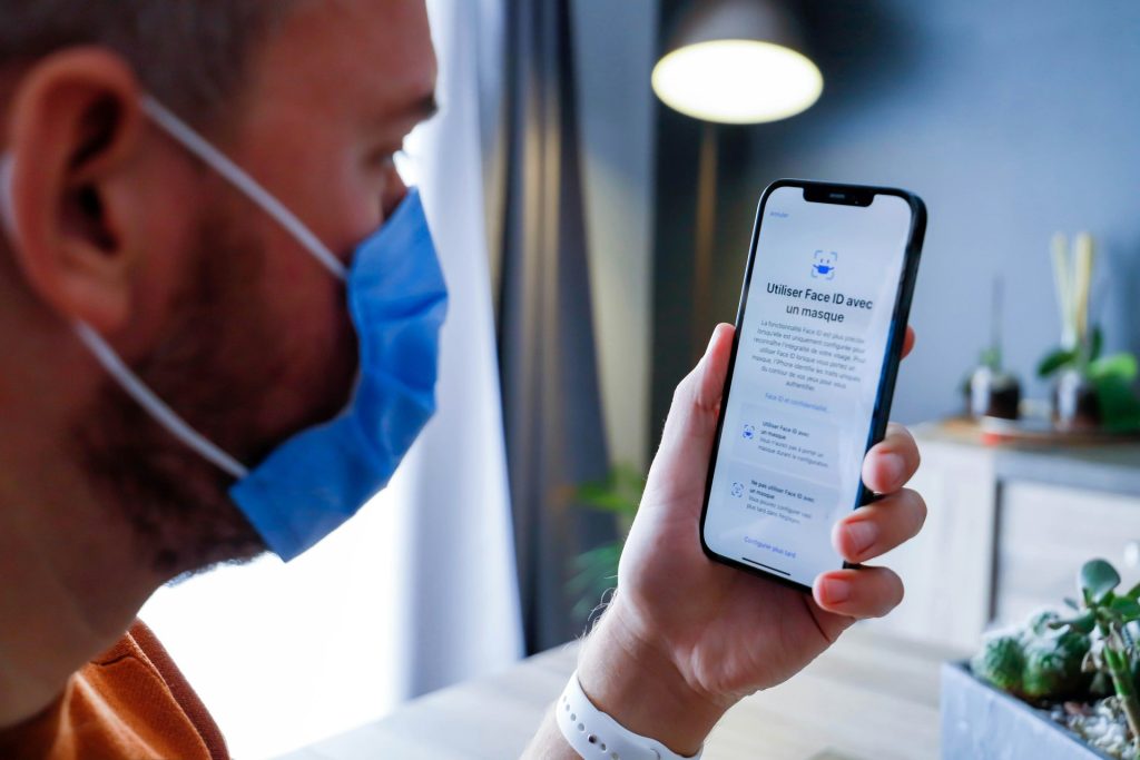 a man wearing a face mask while looking at a cell phone